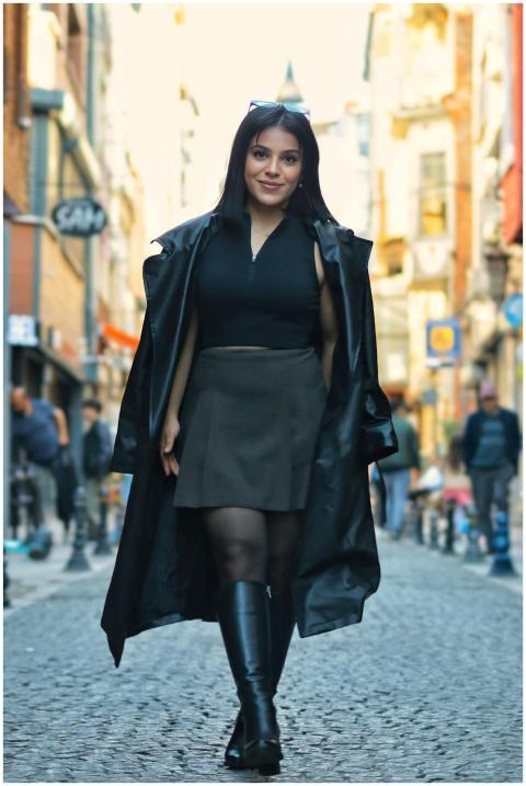 Fashionable woman in boots and coat walking down a