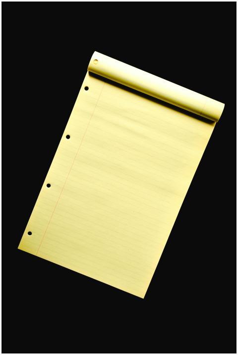 Close-up of an empty yellow notepad with holes aga