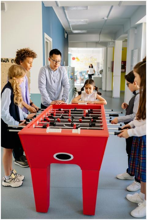 A diverse group of children and a young adult play