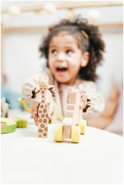 A happy child with curly hair enjoys playing with