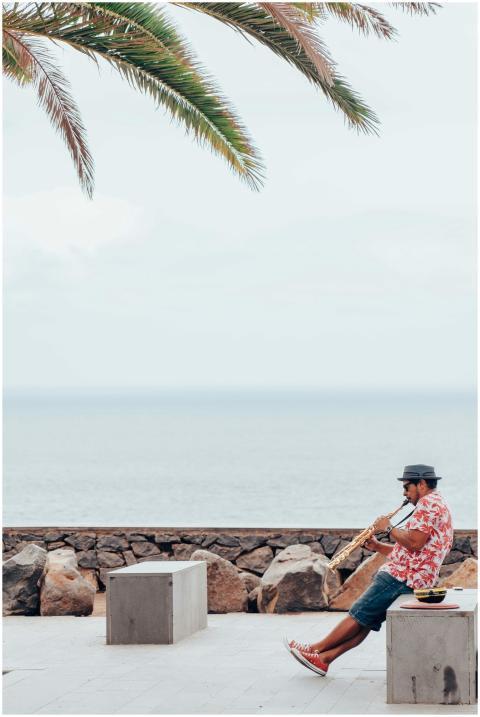 Man playing saxophone by the seaside in Puerto de