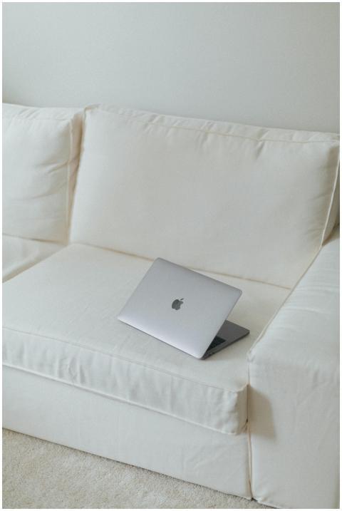 Sleek silver laptop on a clean white sofa in a min