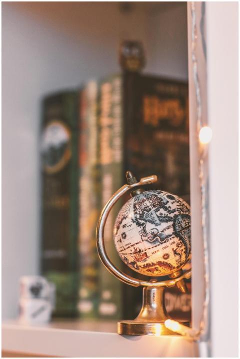 A cozy bookshelf featuring a vintage globe and war