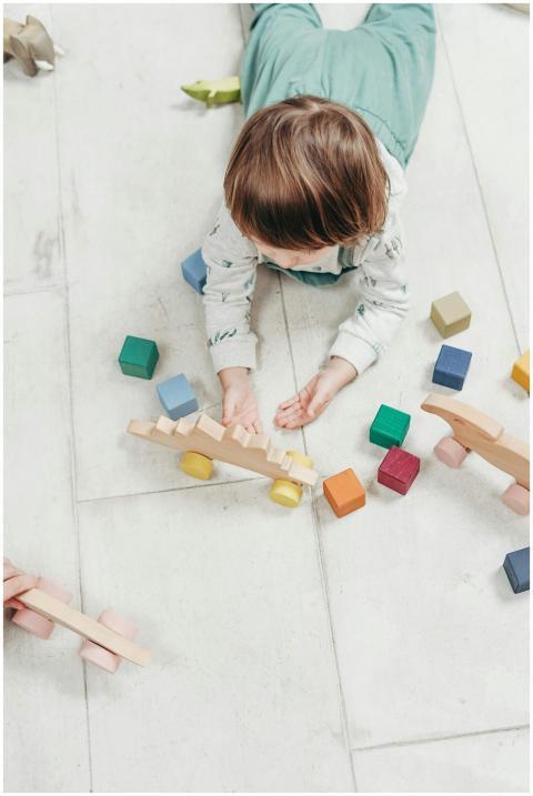 Child playing with colorful wooden toys on a light