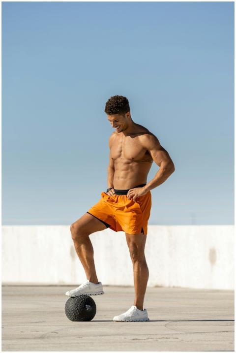Fit man exercises outdoors with medicine ball on a