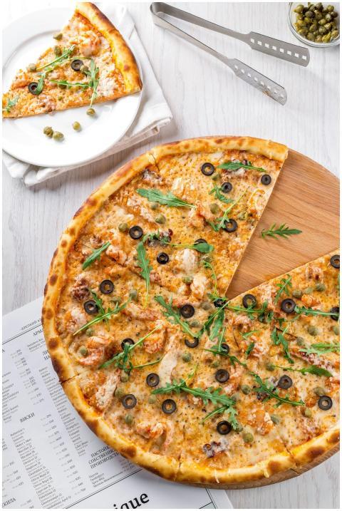 High-angle view of pizza topped with olives, arugu