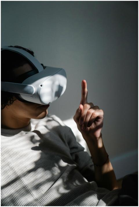 Young man using VR headset indoors, engaging with