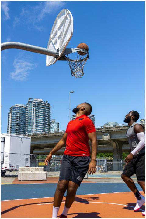 Two men enjoy a basketball game on an outdoor cour