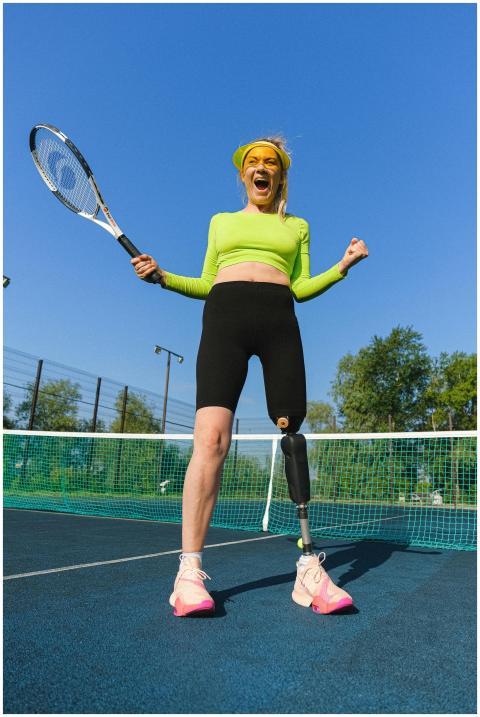 Joyful woman with prosthetic leg celebrating a win