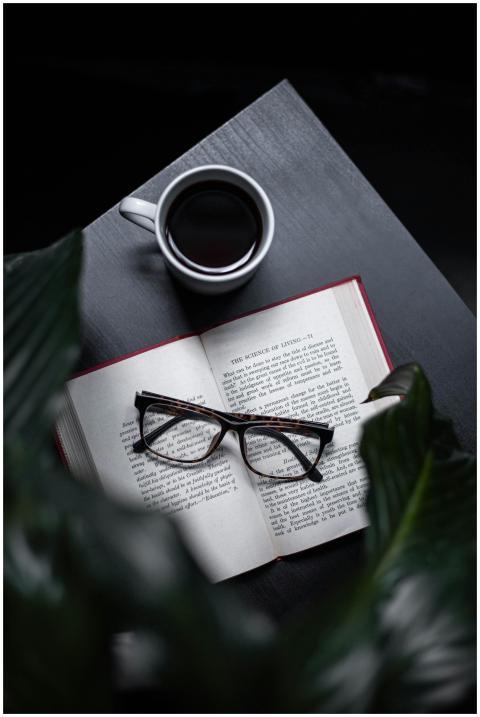 A serene setting with an open book, eyeglasses, an