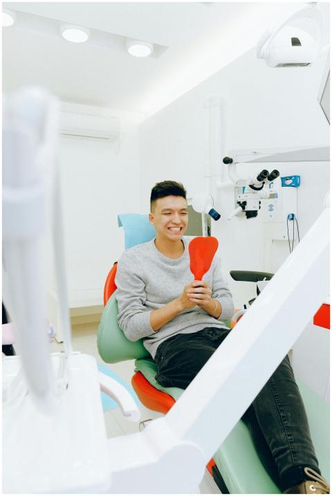 Happy young patient in dental clinic awaiting trea