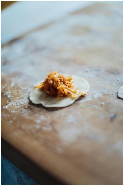 Close-up of dumpling with filling on a floured woo