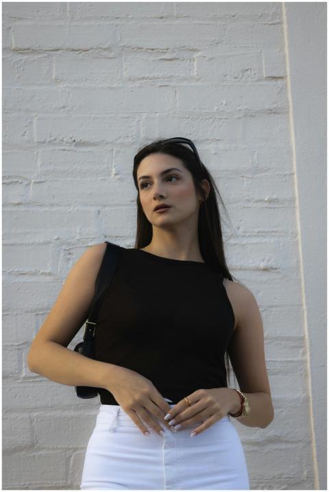 Elegant female model poses in front of a white bri