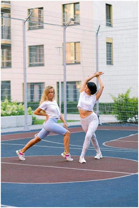 Two young women stretching and exercising outdoors
