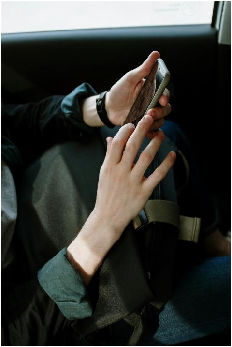 A man interacts with his smartphone while seated i