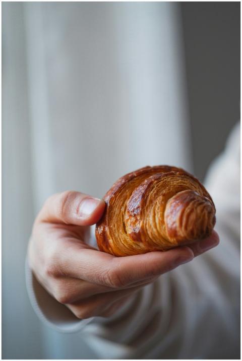 Appetizing croissant held in hand, captured in Bel