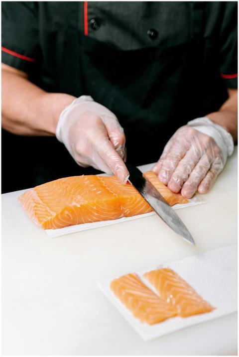 A chef slicing fresh salmon fillets with precision