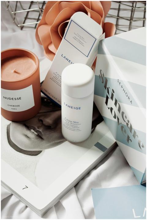 Skincare products and candle arranged in an elegan