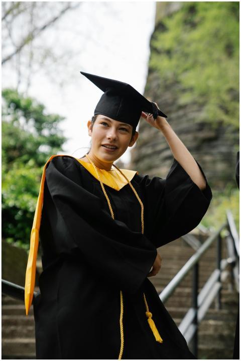 University graduate in cap and gown smiling victor