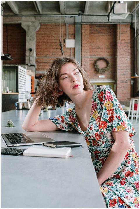 Young woman in a floral dress with laptop working