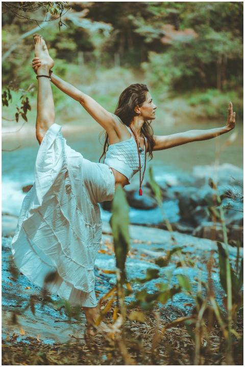 A serene scene of a woman practicing yoga by a pic