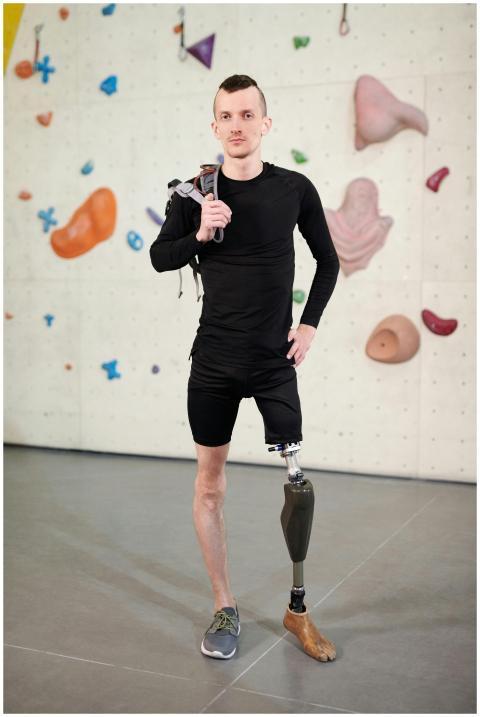 Young man with prosthetic leg confidently posing a