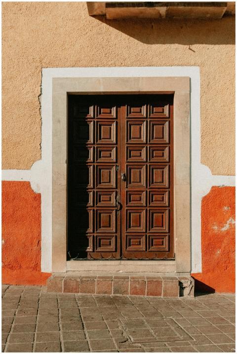A beautifully carved wooden door set in a vibrant