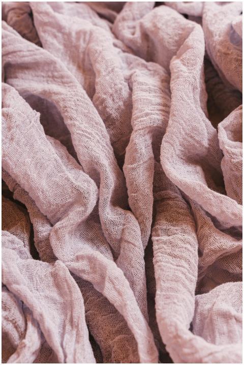 Close-up of crinkled purple linen fabric showcasin