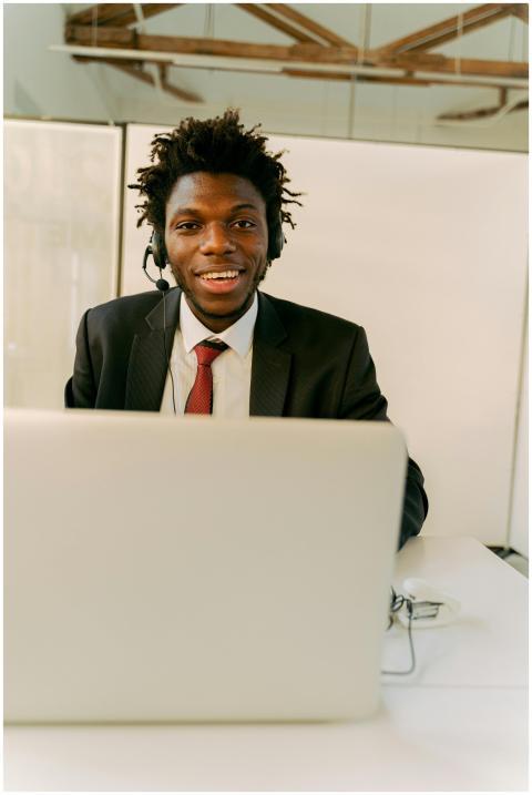 Young man in call center wearing a headset and smi