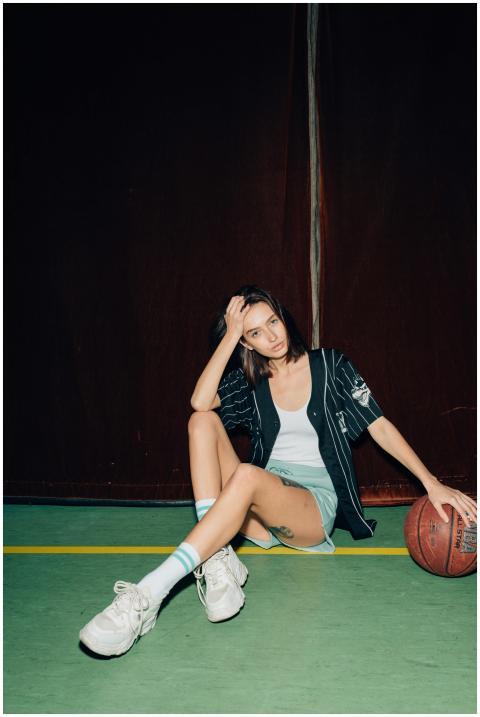 Confident young woman in sporty attire sitting ind