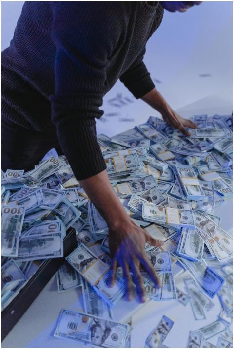 Adult man organizing a massive pile of US dollar b