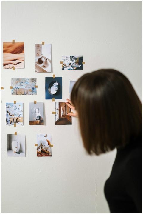 A woman arranges various art photographs on a ligh