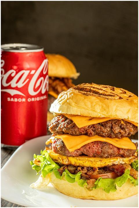 Close-up of a cheeseburger with a Coca Cola can, p