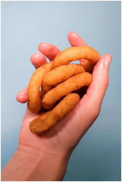 Crop faceless person demonstrating delicious fried