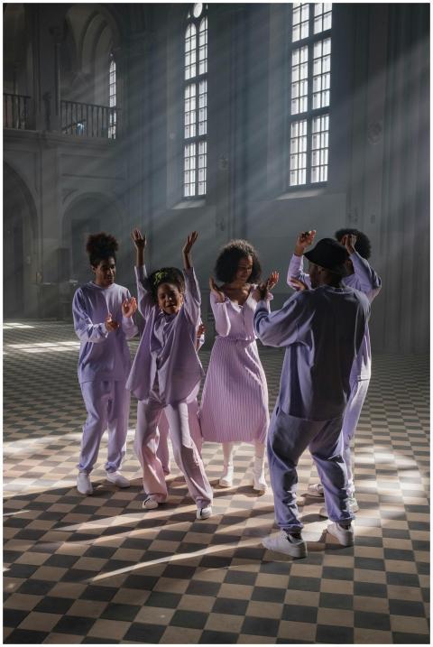 Group of adults dancing joyfully inside a sunlit c