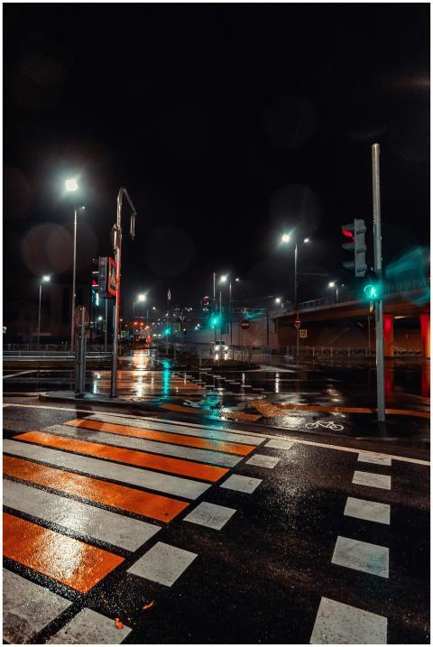 A city street at night with wet pavement reflectin