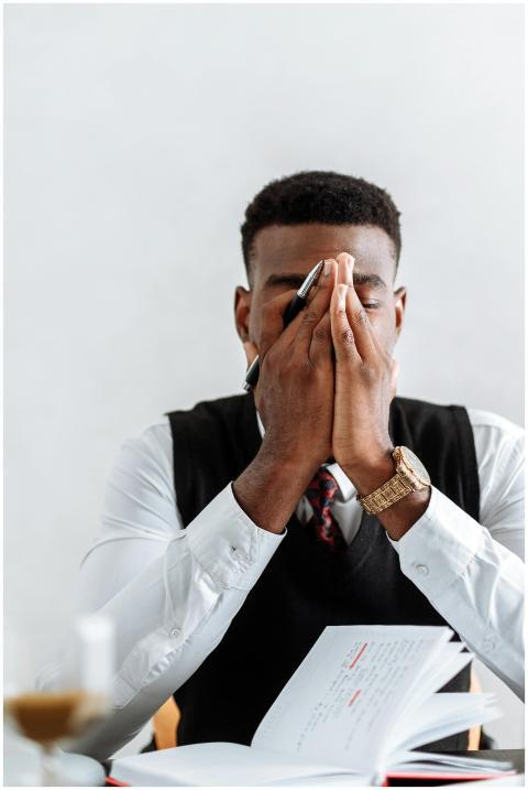 A businessman in corporate attire looks stressed,