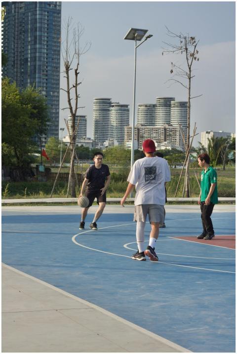 Young adults playing basketball on an outdoor cour
