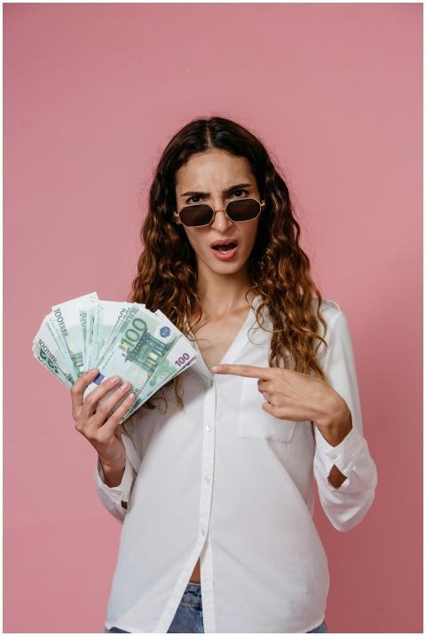Young woman in sunglasses holding euro banknotes a