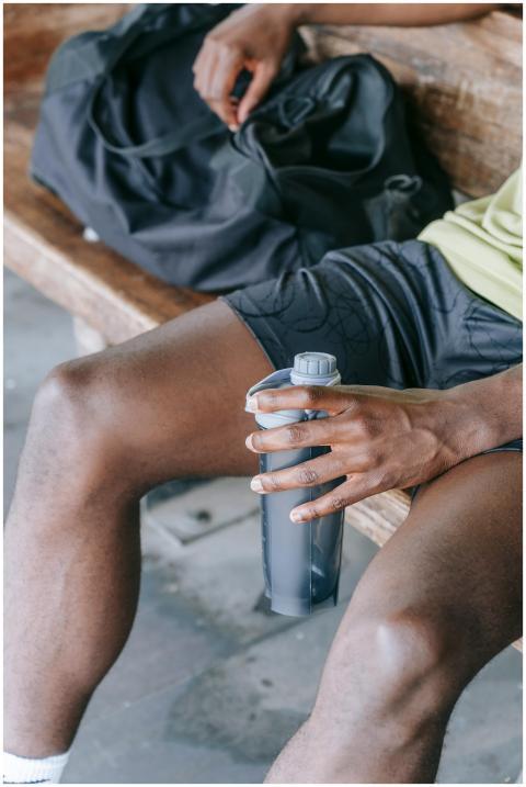 A close-up of an athlete sitting on a bench, holdi