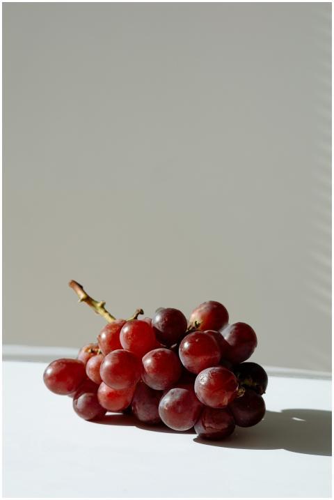 A bunch of red grapes in a minimalist setting with