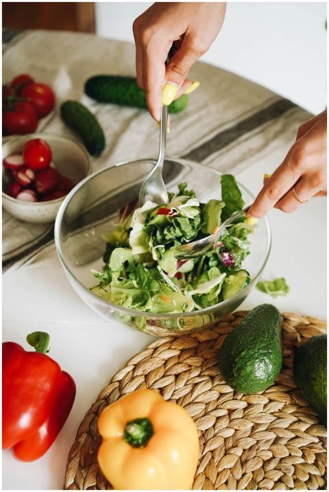 Hands preparing a fresh vegetable salad with cucum