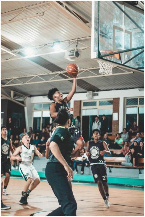 Action-packed indoor basketball game with athletes