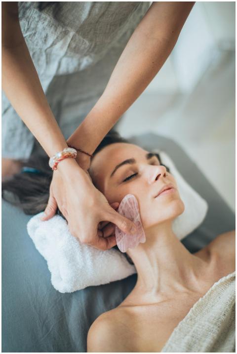 A woman relaxes during a gua sha facial massage at