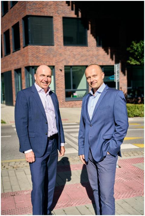 Two businessmen in formal attire standing outside