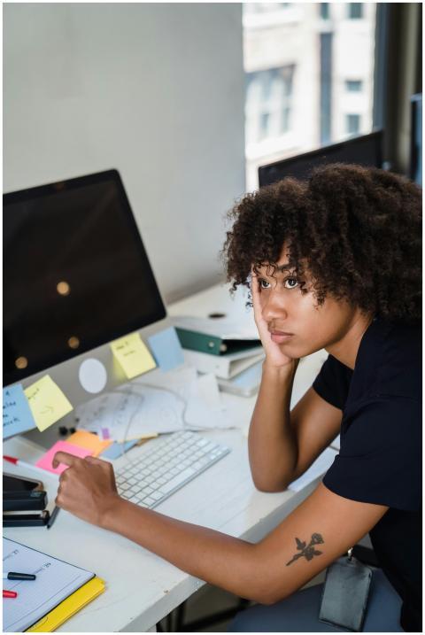A woman looks tired while sitting at her work desk