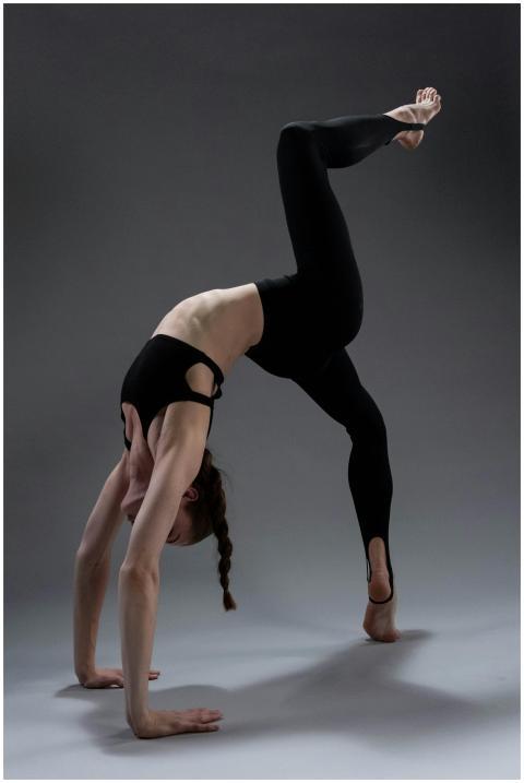 Adult woman practicing urdhva dhanurasana yoga pos