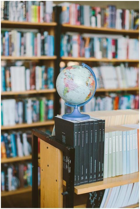 A globe and book stack in a library, symbolizing e