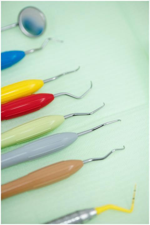 Close-up of colorful dental tools arranged on a gr
