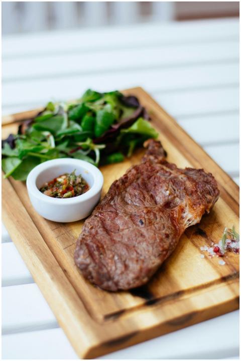 Juicy grilled steak served with fresh herb salad a